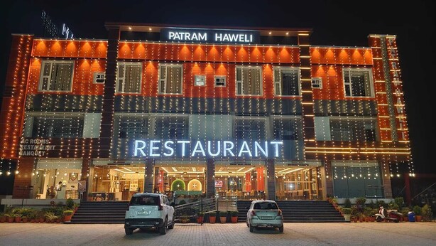 A restaurant named 'PATRAM HAWELI' with a modern facade and a sign indicating 'AC ROOMS RESTAURANT BANQUET.' - Patram Haveli (Roorkee)