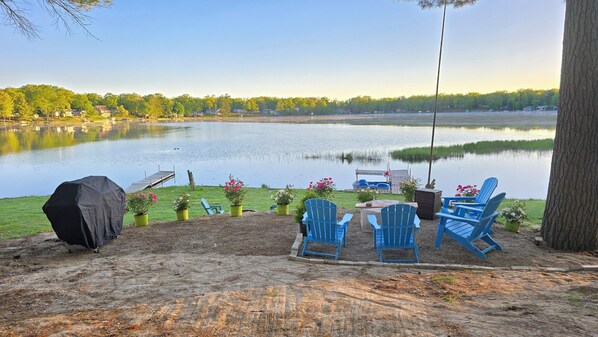 A lakeside deck with chairs, a grill, and a dock. - NEW!  Villa Adonis - Lakefront, Dog-Friendly, and Gorgeous!  Includes NEW 6-PERSON HOT TUB, Central Air, and Water Toys! (National City)