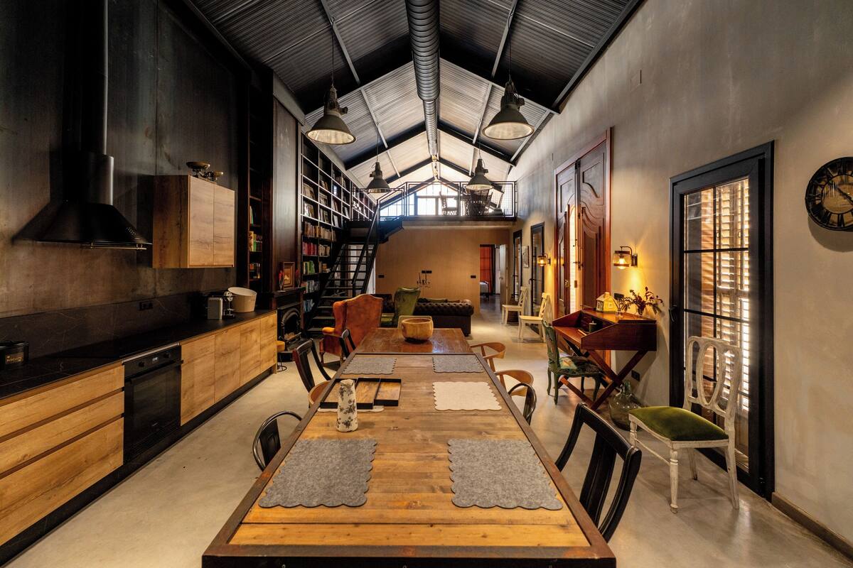 A spacious kitchen with a high ceiling, wooden cabinets, and a central island.