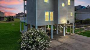 A two-story house with a balcony, a small porch, and a staircase leading to an upper level. - Ocean Views Hear The Waves Sleeps 8 Walk to Beach (Bolivar Peninsula)