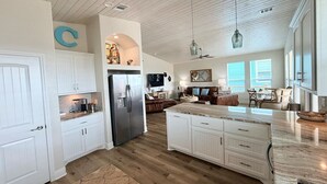 A spacious kitchen with white cabinetry, a large island, and a wooden ceiling. - Ocean View•New Build • sleeps 9• Fenced Yard (Bolivar Peninsula)