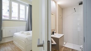 A hotel room with a bed, a bathroom with a shower, and a window with curtains. - Italianway Comfort - Cicco Simonetta 16/a (Milan)