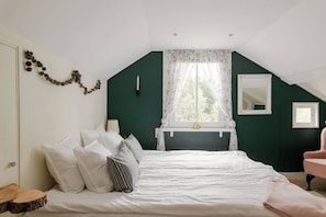 A bedroom with a bed, a window with lace curtains, a bedside table, and a chair. - 3BR In Kosta - Fire pit, gathering room, Lake &Pub (Källeskruv)