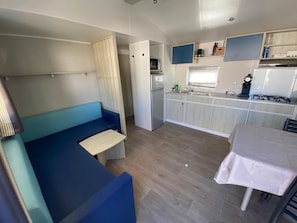 A compact kitchenette with a refrigerator, sink, and stove.