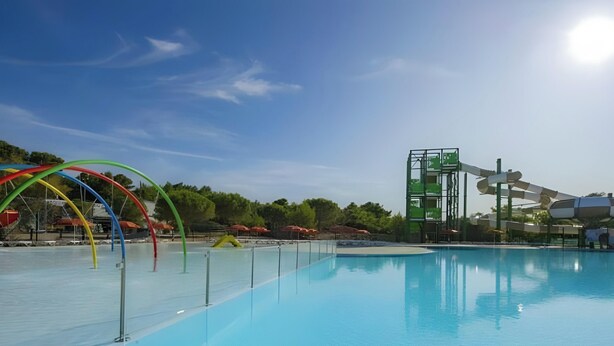 A swimming pool with a water slide and a climbing structure. - Bungalow 'Mobil-home Narbonne Plage' with Shared Pool, Private Terrace and Air Conditioning (Narbonne)