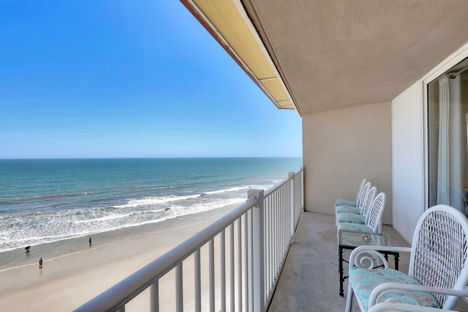 Un balcon avec vue sur la plage et l’océan.