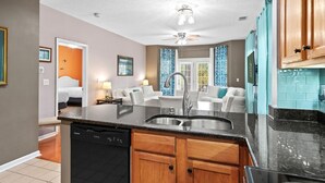 A modern kitchen with a dishwasher, wooden cabinets, a sink, and a ceiling fan. - On the Links-9th Hole- L egends Stay (Myrtle Beach)