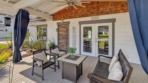 A covered patio with a ceiling fan, a welcome sign, and outdoor furniture. - Completely re-done 4 bedroom pet-friendly home. Great location. (St. Simons Island)