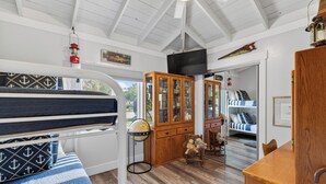 A room with a bunk bed, wooden cabinet, globe, and a television. - Completely re-done 4 bedroom pet-friendly home. Great location. (St. Simons Island)