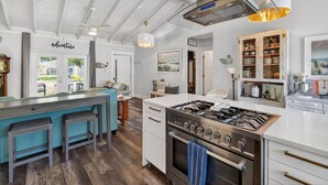 A modern kitchen with a central island, stainless steel appliances, and a white countertop. - Completely re-done 4 bedroom pet-friendly home. Great location. (St. Simons Island)