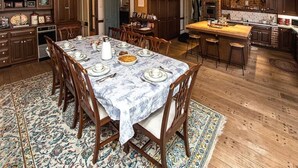 Una cocina amplia con gabinetes de madera, un área de comedor con mesa de mármol y una isla grande con taburetes.