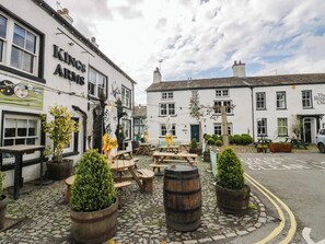 A traditional pub with outdoor seating, stone paving, and potted plants. - Courtyard Cottage (Grange-over-Sands)