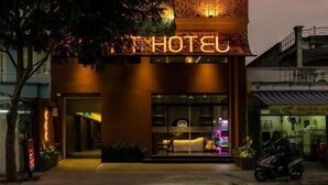 A hotel with a unique facade featuring intricate patterns and a neon sign. - PYNT HOTEL 8 (Ho Chi Minh City)