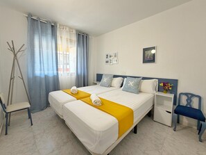 Ein Hotelzimmer mit Doppelbett, einem Sessel, einem Nachttisch und einem Bild an der Wand.