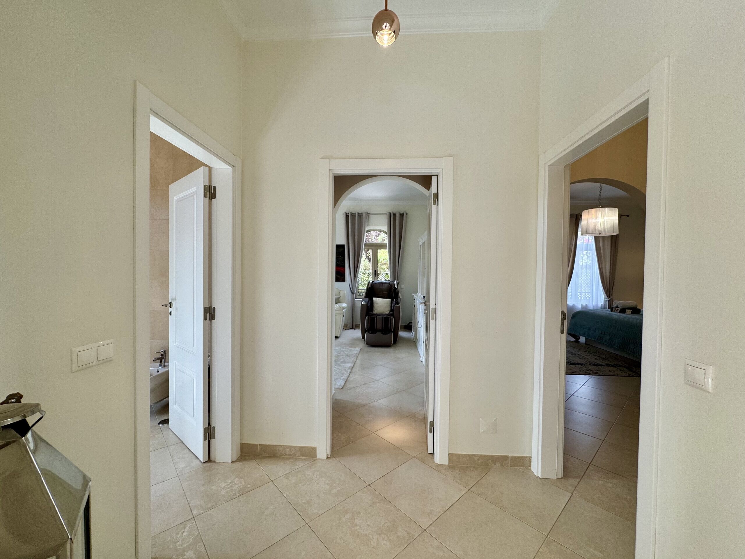 Un couloir qui donne sur un salon, une salle à manger et une chambre à coucher.