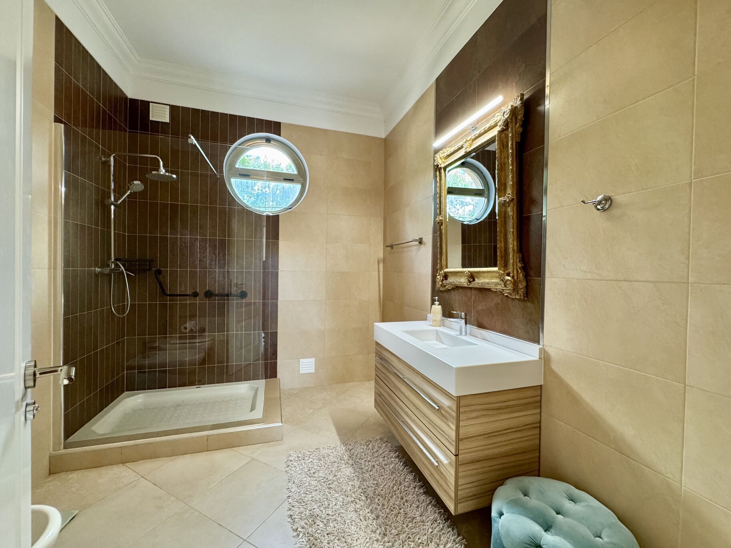 A modern bathroom with a walk-in shower, a bathtub, a vanity with a mirror, and a toilet.