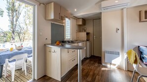 Una cocina moderna con armarios de madera, una estufa a gas y un comedor con mesa y sillas.
