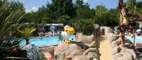 En vandpark med pool, rutsjebaner og en maskot.