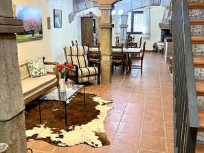 A living room with a sofa, chairs, a dining table, and a staircase. - Spacious apartment - 8 guests, heart of Riudoms (Riudoms)