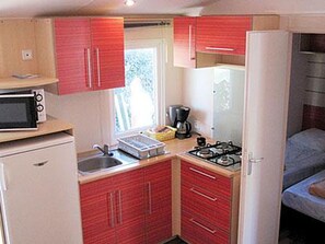 Eine kleine Küche mit Mikrowelle, Herd und Kühlschrank.