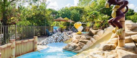 A pool area with a rock formation and a statue.
