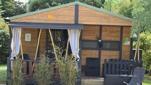 Eine kleine Holzhütte mit einer Veranda, einem Stuhl und einem Tisch.