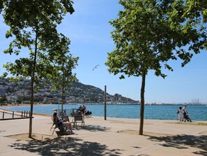 Ein Park am Wasser mit Bänken, Bäumen und Blick auf das Wasser.