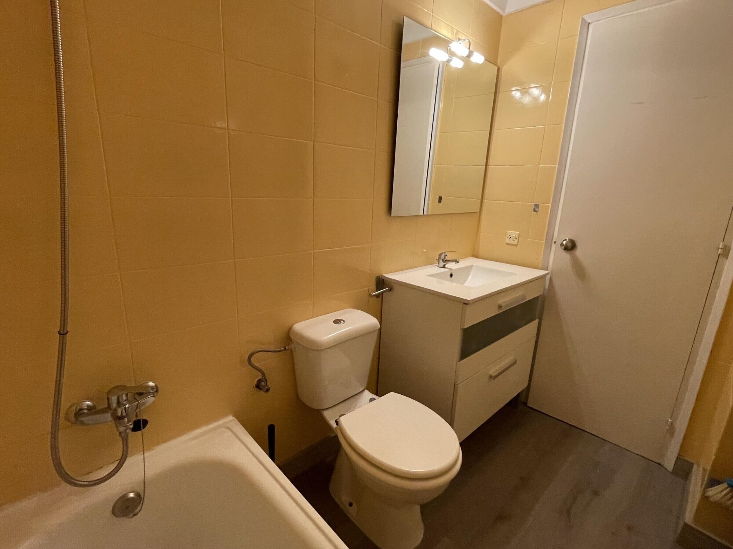 Une salle de bain équipée d’une baignoire, de toilettes, d’un lavabo et d’un miroir.