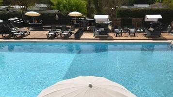 Une piscine équipée de chaises longues et de parasols.