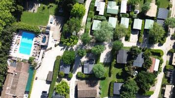 Vue aérienne d’un quartier résidentiel avec des maisons, une piscine et des espaces verts.