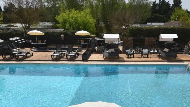 A swimming pool with lounge chairs and umbrellas.