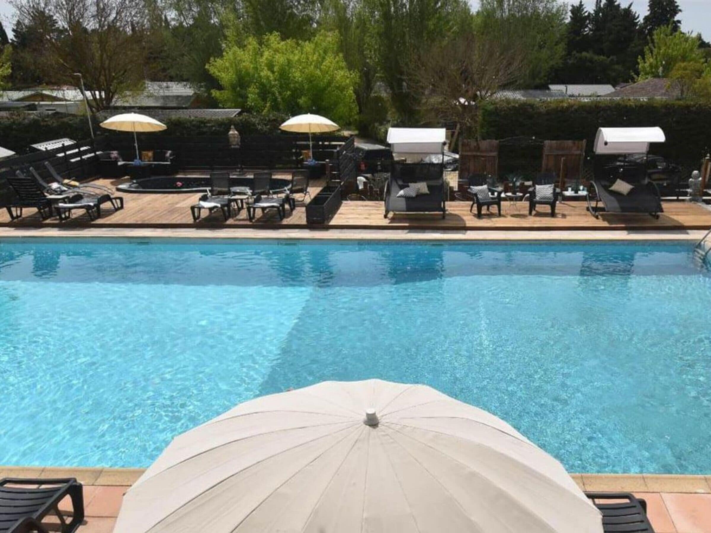 Une piscine équipée de chaises longues et de parasols.