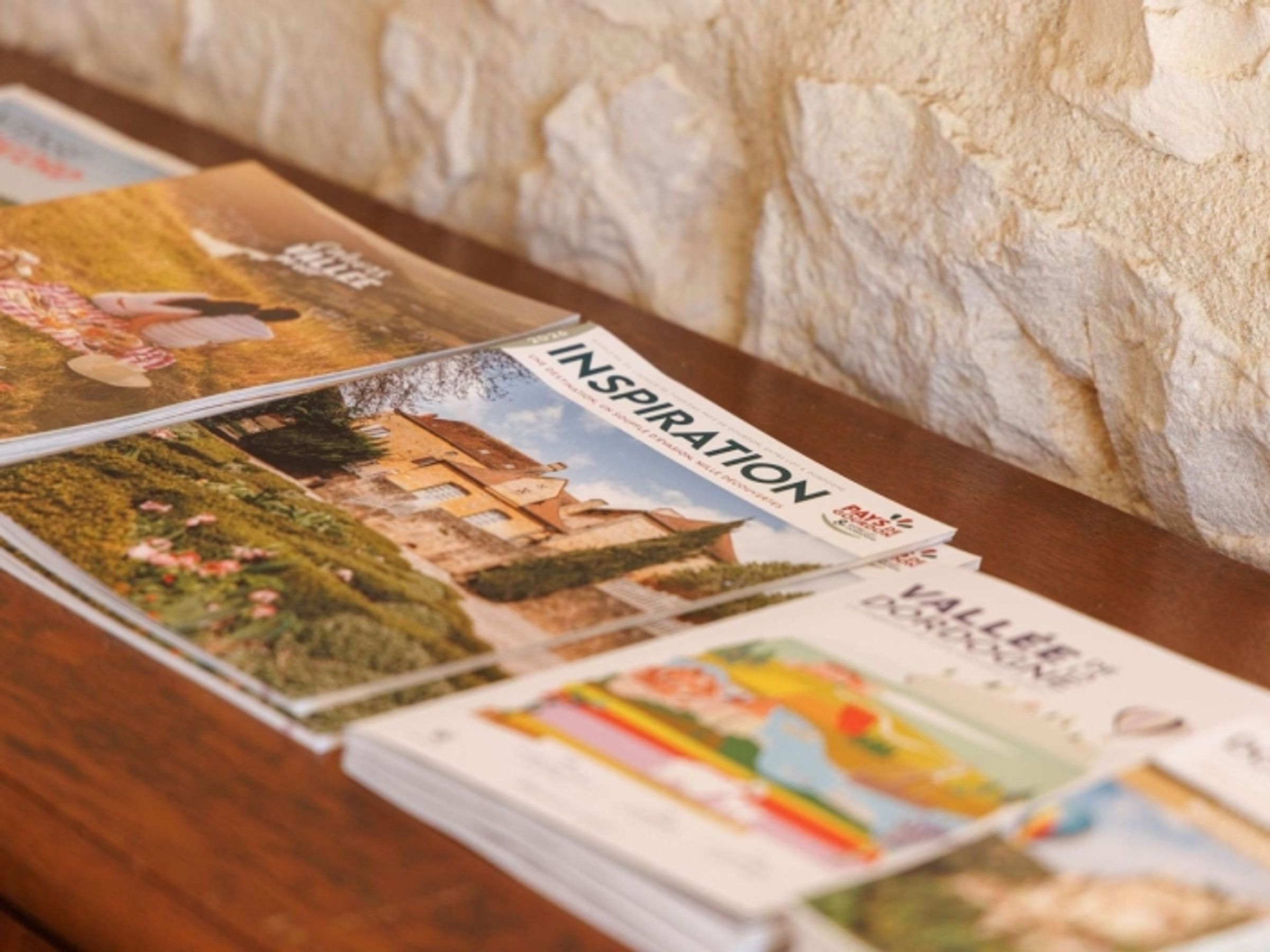 Une pile de magazines de voyage dont on peut voir les titres et les images de paysages et d’édifices.