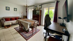 Un salon comprenant un canapé, une table à manger et un bureau avec une chaise.
