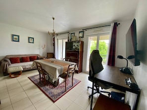 Un salon comprenant un canapé, une table à manger et un bureau avec une chaise.