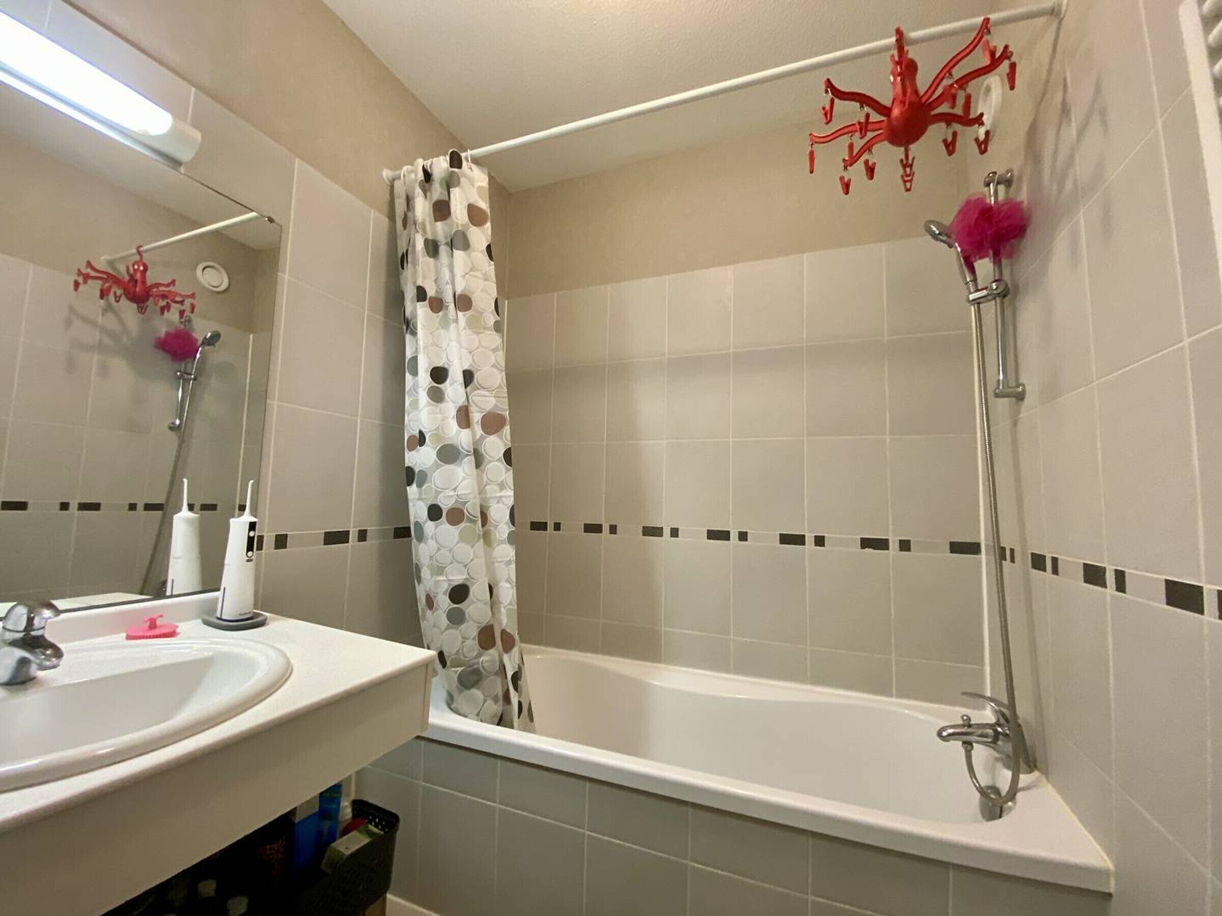A bathroom with a bathtub, a shower, a sink, and a mirror.