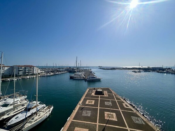 A marina with boats docked, a clear sky, and a sun shining. - Loft studio with sea view - 4 guests (Cap d'Agde)