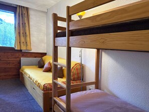 A bunk bed room with a window, wooden walls, and a lamp. - Spacious studio with WiFi, view - 4-5 guests (Les Orres)