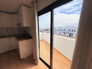 Ein Balkon mit Blick auf Gebäude und einen klaren Himmel.