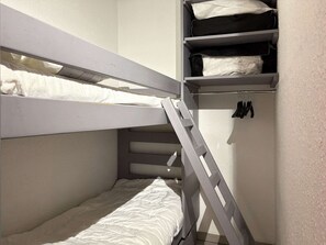 A bunk bed with a ladder, a shelf with folded clothes, and a hanging rack with shoes. - Studio in resort, valley view - 4 guests (Les Orres)