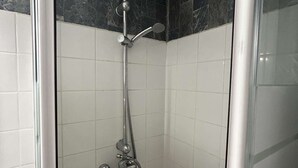 Eine Dusche mit Duschkopf, Wandarmatur und Handbrause.