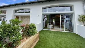 Een modern huis met een verzorgd gazon, grote ramen en een stenen muur.