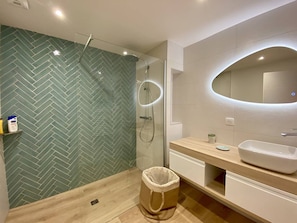 A modern bathroom with a herringbone tile backsplash, a glass-enclosed shower, a wooden vanity, and a large mirror. - Terraced house in city center - 4 guests (Louhossoa)