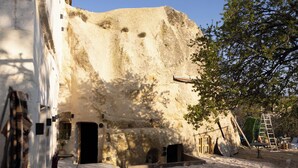 A stone building with a doorway, a small table, and a ladder. - Soul of Cappadocia Hotel (Urgup)