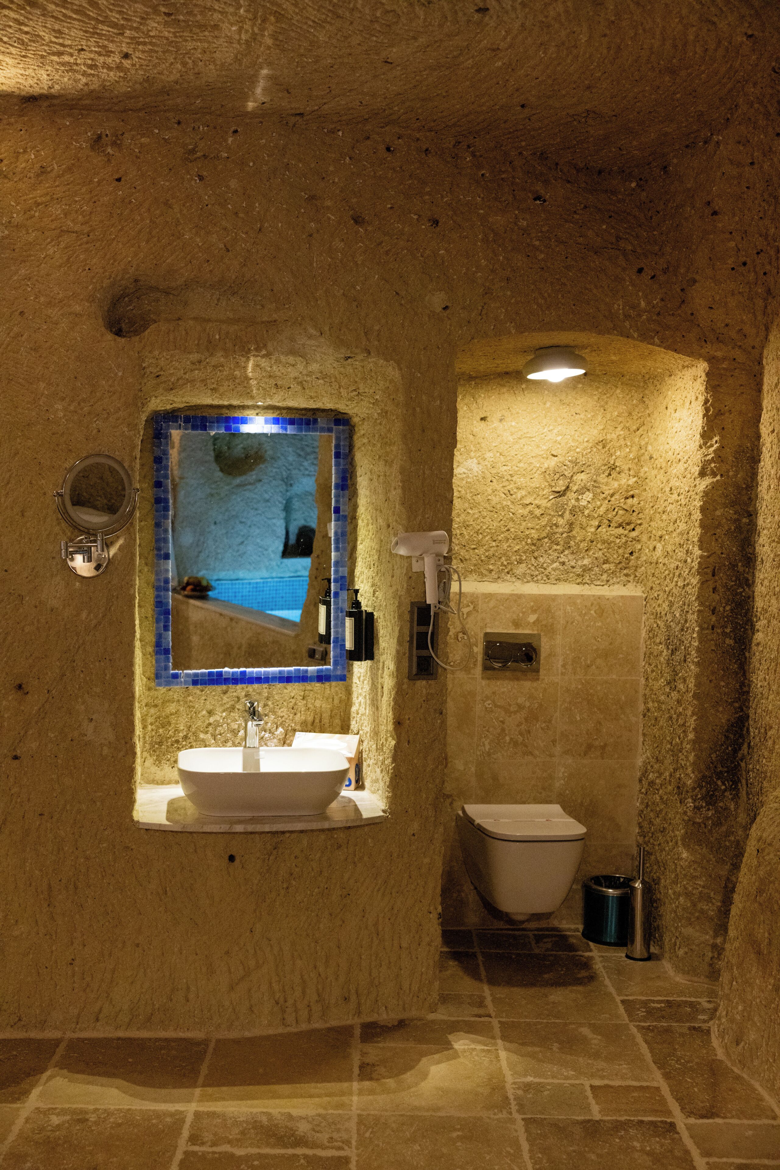 A bathroom with a sink, mirror, and toilet.