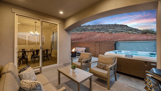 Un patio con un jacuzzi, mobiliario y vistas a un paisaje desértico.
