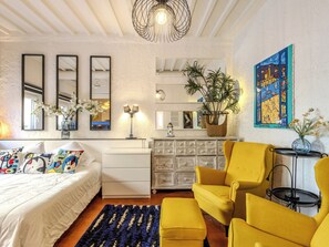 Ein Schlafzimmer mit einem Bett, einem Schminktisch, einem Spiegel, einer Lampe und einem Stuhl.