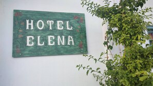 A green sign with 'HOTEL ELENA' written on it, mounted on a white wall. - Hotel Elena -sunny Seaside Balcony Suite in Skyros (Skiros)