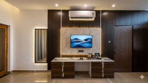 A modern hotel room with a marble vanity, a flat-screen TV, and a large mirror. - Corbett Hidden Grove (Ramnagar)