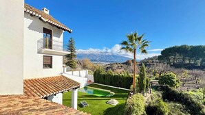 A white building with a tiled roof, a balcony, and a swimming pool. - Villa Rural El Mayorazgo en Saleres - Granada (Saleres)